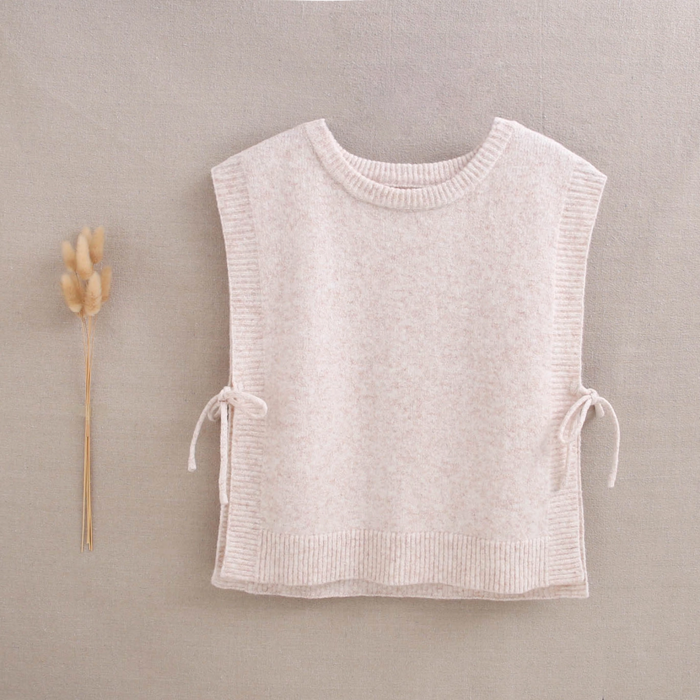 Chaleco de punto para niña con color beige con lazos laterales