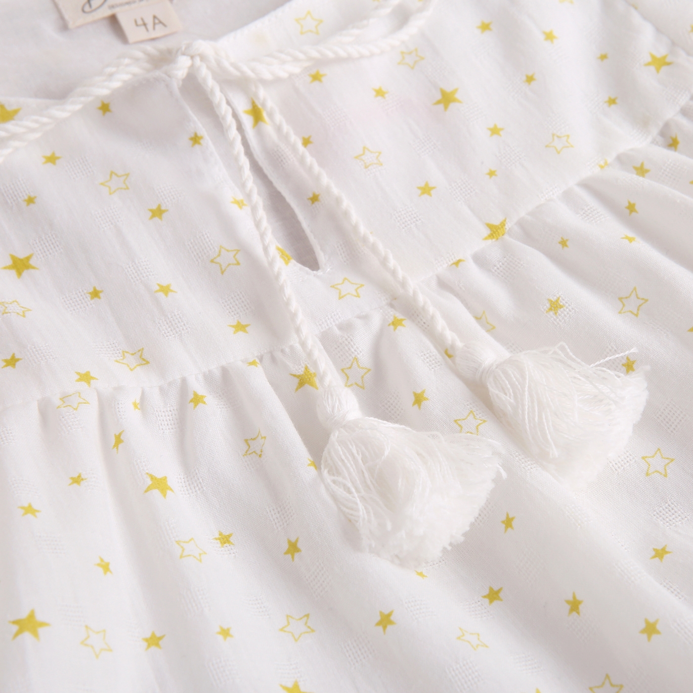 Imagen de Vestido de niña blanco con estampado de estrellas en color amarillo
