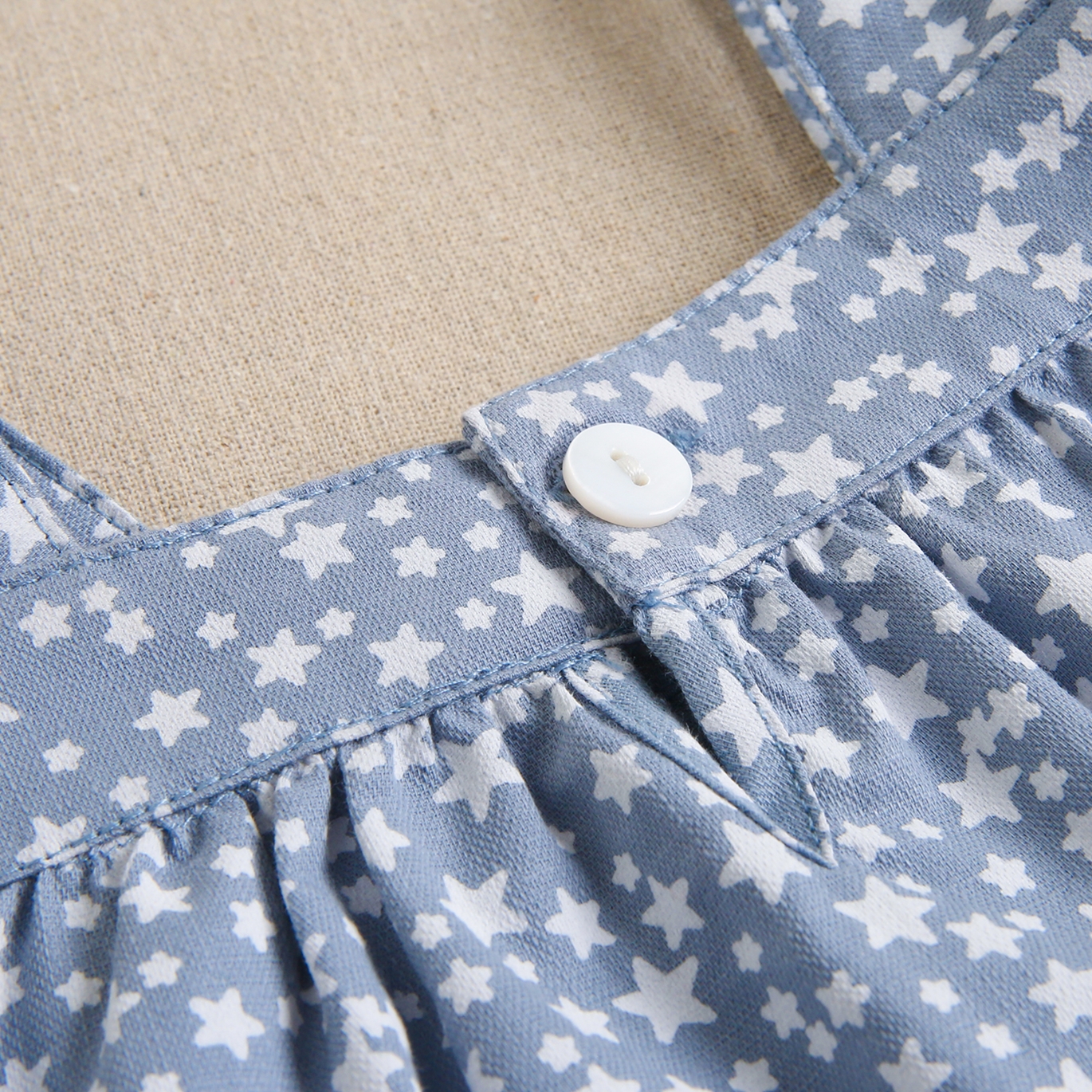 Imagen de Vestido de bebé niña con cubrepañal azul grisáceo con estrellas blancas