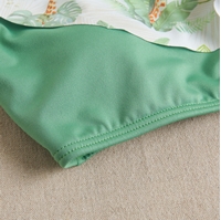 Imagen de Bikini de teen niña en color verde con estampado asimétrico y con lazo 