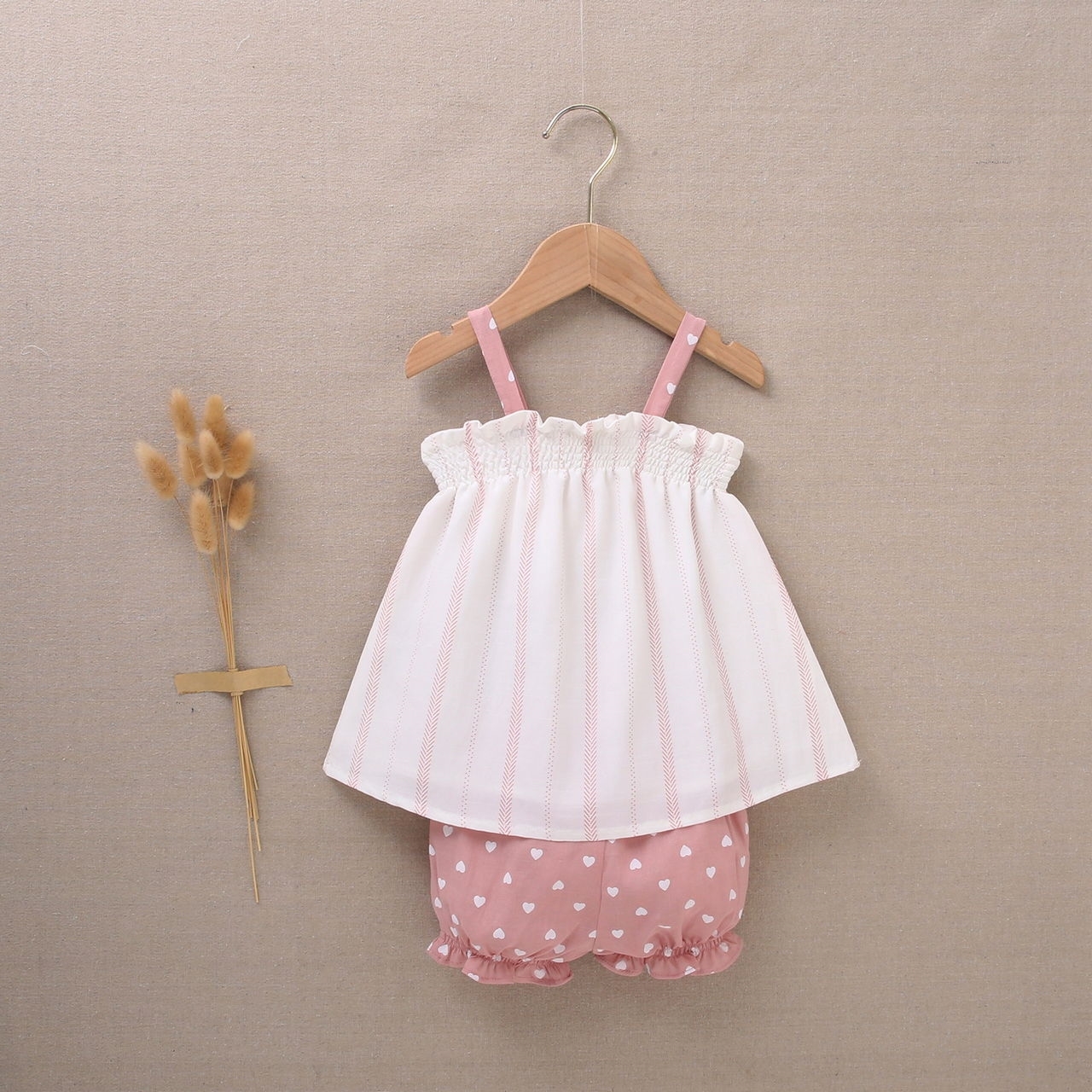 Imagen de Vestido de bebé niña con cubrepañal blanco con estampado en tonos rosas y combinado con rosa y corazones blancos