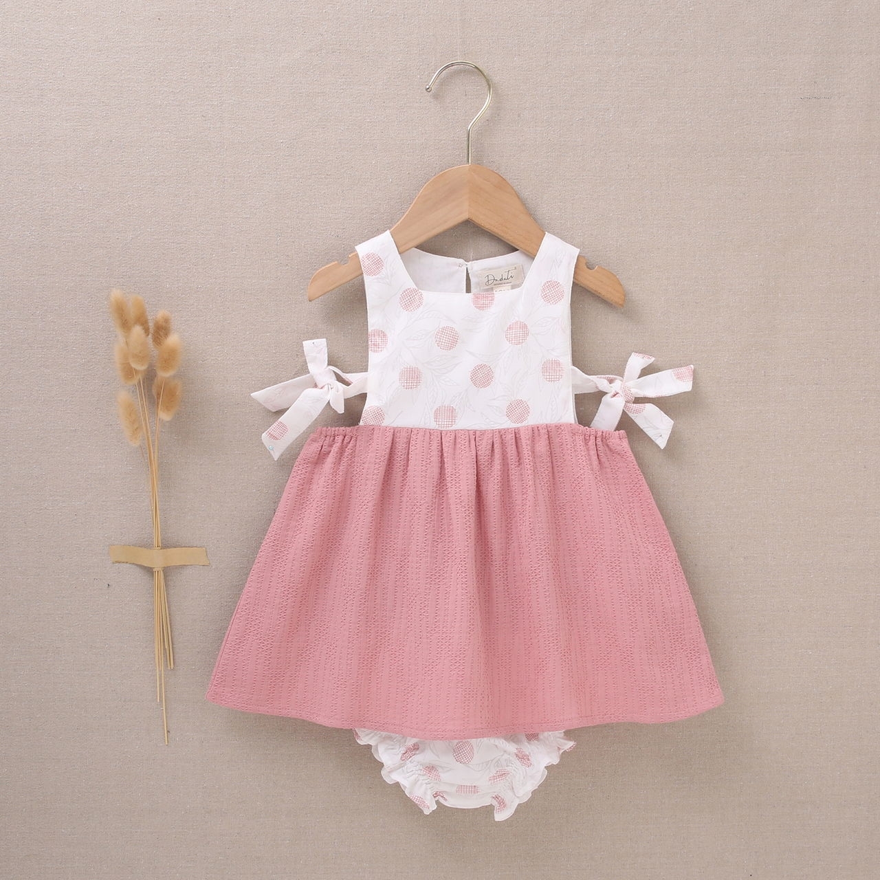 Imagen de Vestido de bebé niña con cubrepañal en rosa combinado con estampado