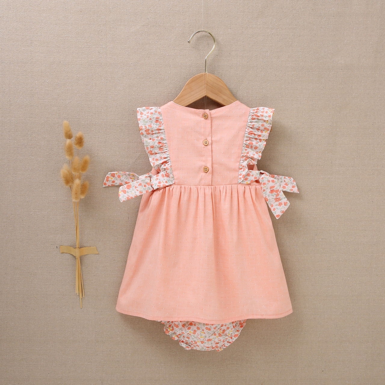 Imagen de Vestido de bebé niña con cubrepañal rosa combinado con estampado de flores