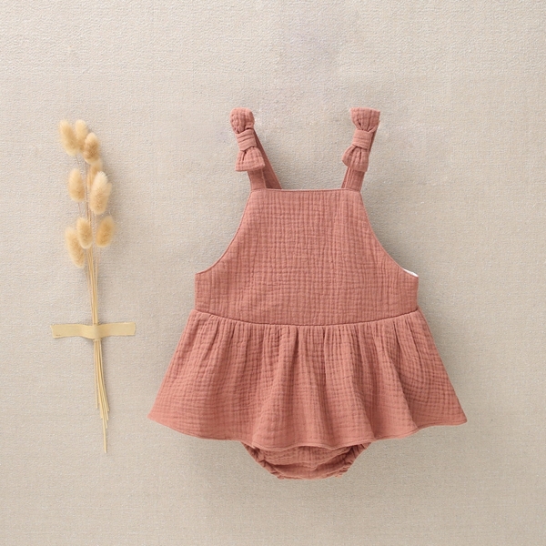 Imagen de Pichi de bebé niña con tirantes de lazo y volantes en muselina terracotta