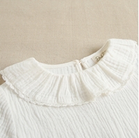 Imagen de Blusa de niña con cuello de volantes y manga larga en muselina blanca