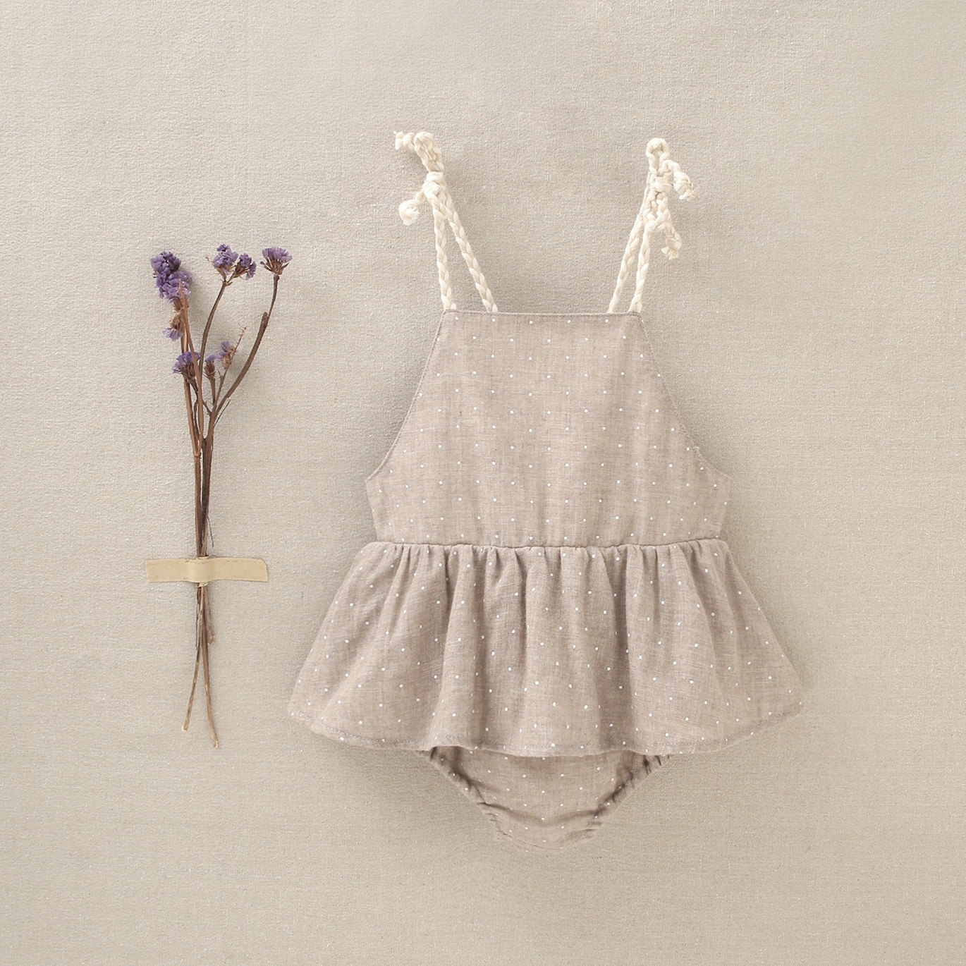 Imagen de Pichi de bebé niña de tirantes y tejido beige con topos blancos