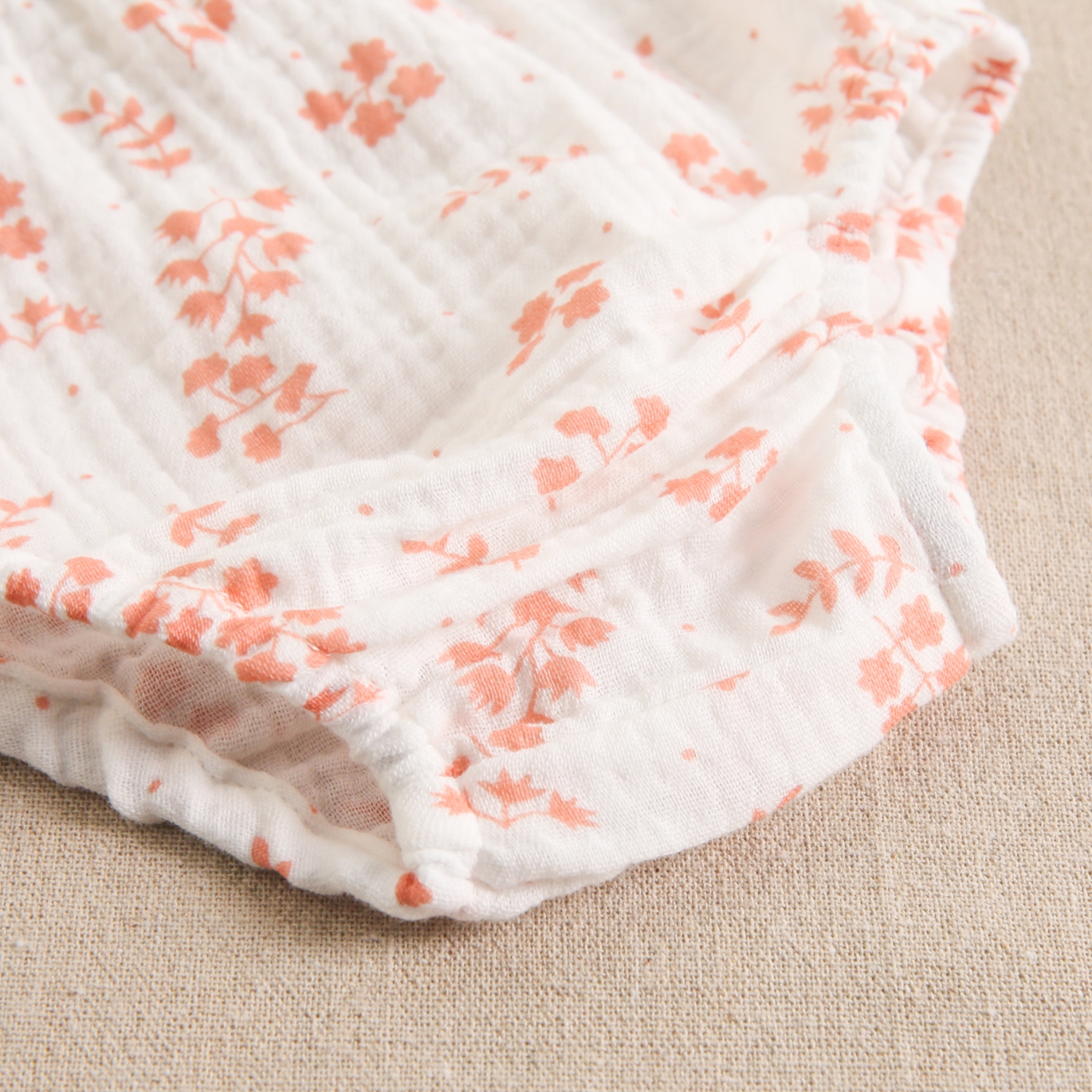 Imagen de Vestido de bebé niña en color coral combinado con bambula blanca con detalle de flores