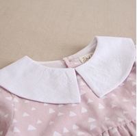 Imagen de Vestido niña rosa palo de franela con estampado de triángulos blancos y cuello peter pan