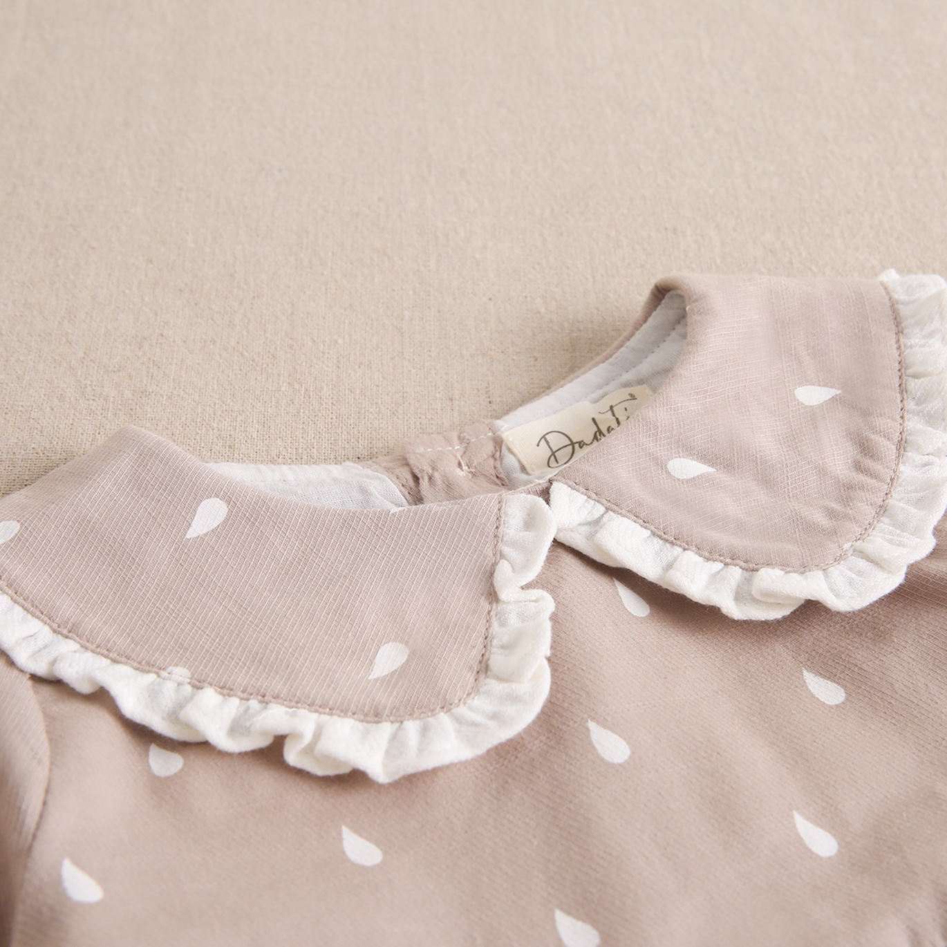 Imagen de Vestido de bebé niña beige con gotas de agua blancas y cuello bebé