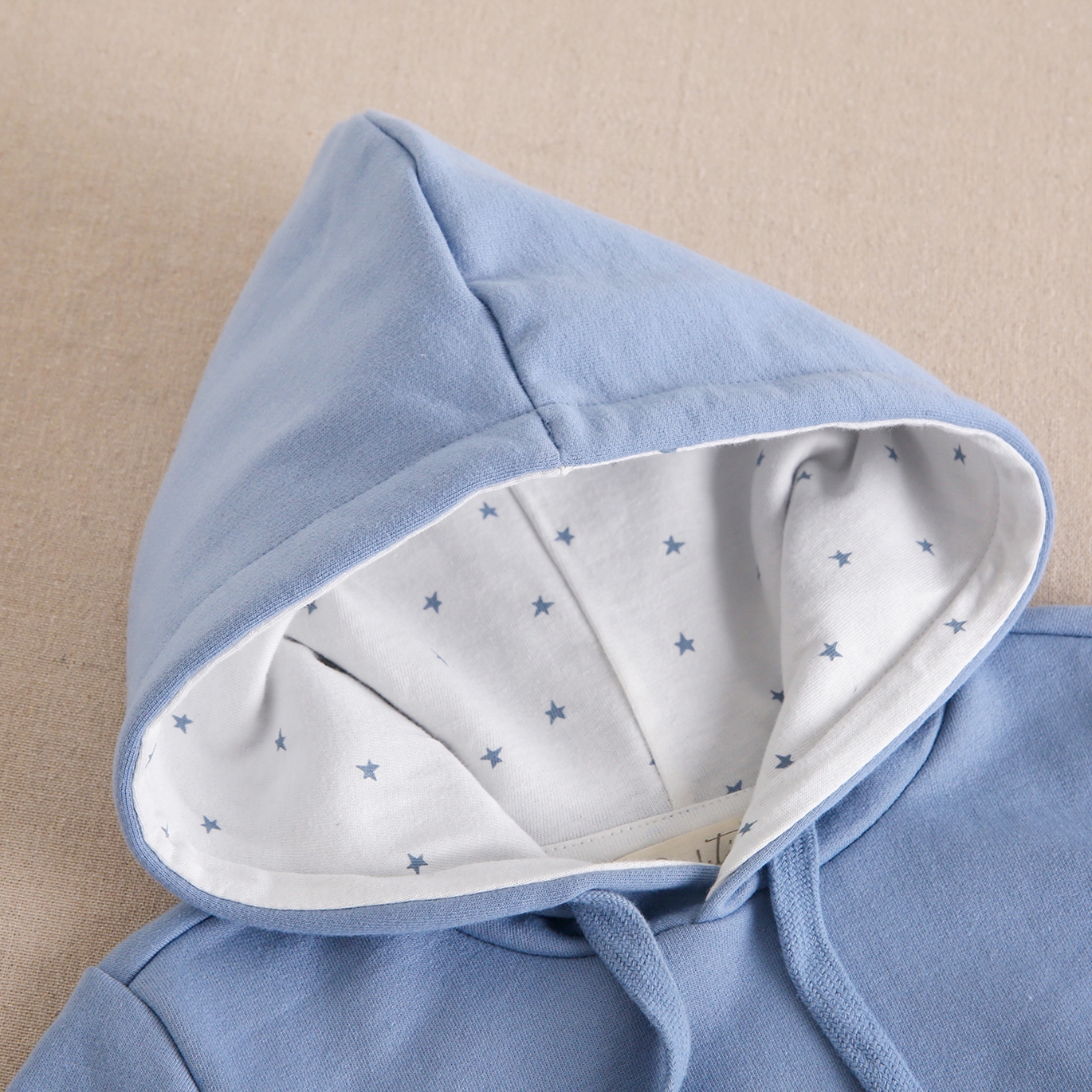 Imagen de Sudadera de junior con capucha en color azul claro con parche bordado de estrella blanco