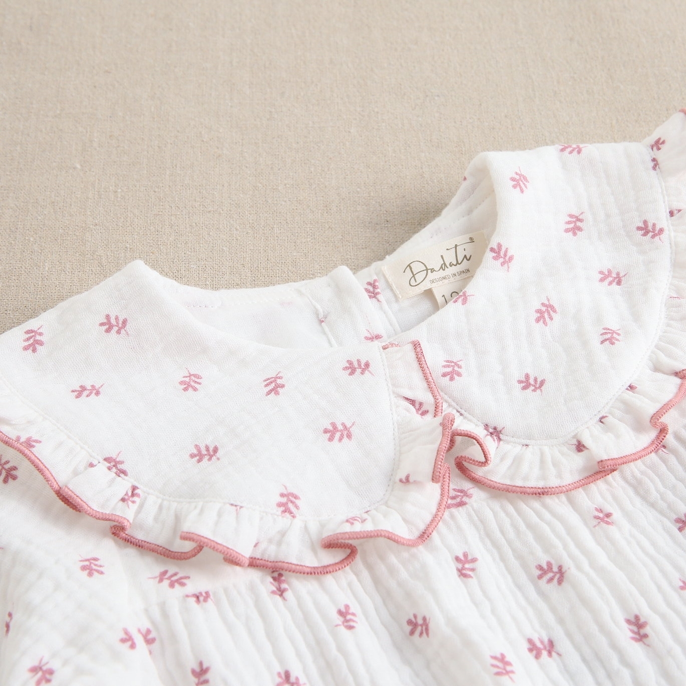 Imagen de Ranita de bebé niña con cuello peter pan con tejido muselina blanca de ramitas rosas