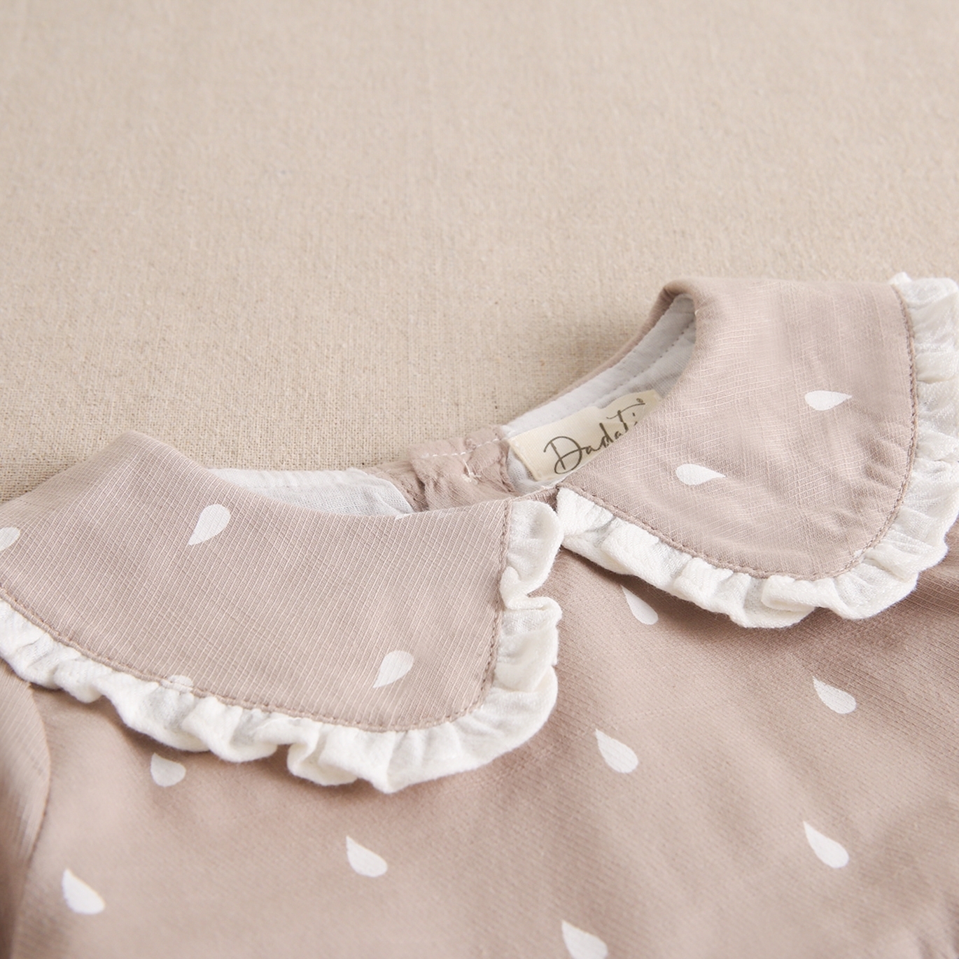 Imagen de Vestido de bebé niña beige con gotas de agua blancas y cuello bebé