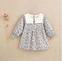 Imagen de Vestido de bebé niña con estampado de hojas azul y mostaza con cuello babero blanco