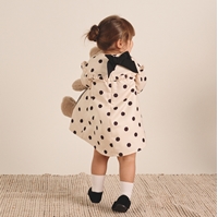 Imagen de Conjunto de bebé niña de vestido color crudo de lunares negro con lazo y calcetines blancos con pompón y abrigo acolchado camel